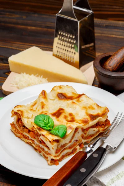 Gedeelte van smakelijke lasagne op houten achtergrondkleur — Stockfoto