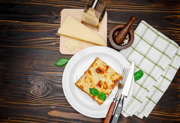 Část chutné lasagne na dřevěné pozadí — Stock fotografie
