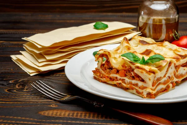 Část chutné lasagne na dřevěné pozadí — Stock fotografie