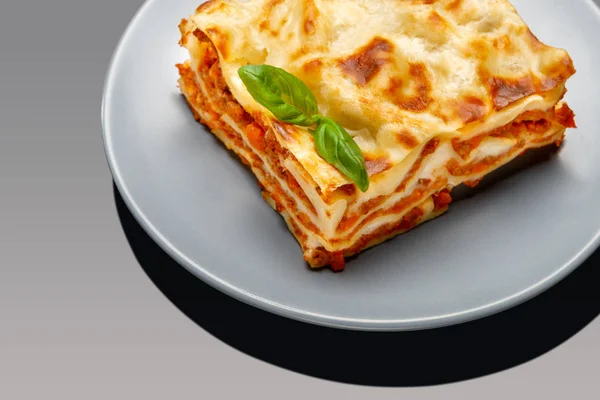 Portion de lasagnes savoureuses sur fond gris — Photo