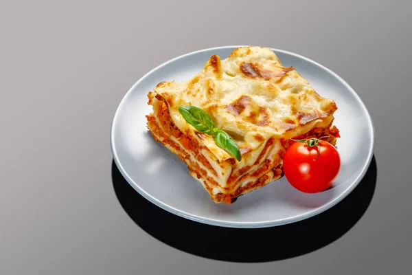 Porzione di gustose lasagne su fondo grigio — Foto Stock