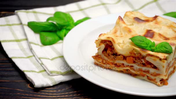 Portion of tasty lasagna on wooden backgound — Stock Video