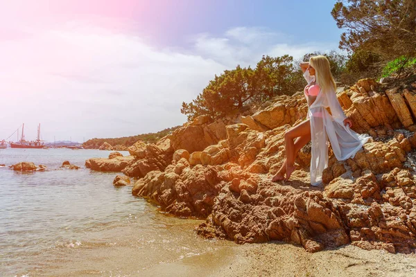 Schöne Frau sitzt auf einem Felsen Ozeanküste — Stockfoto