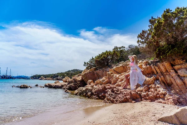 Hermosa mujer sentada en una orilla del océano — Foto de Stock
