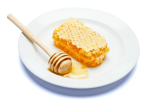 Favo de mel com mel na placa isolado fundo branco — Fotografia de Stock