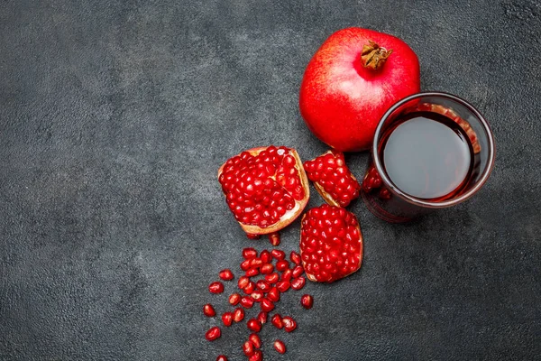 Granatäpple juice och frön närbild på mörk konkreta bakgrund — Stockfoto