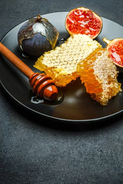 Инжир с медом на тарелке на темном бетонном фоне — стоковое фото