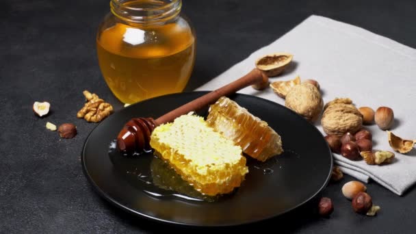 Peine de abeja con miel en el plato. fondo de hormigón oscuro — Vídeo de stock