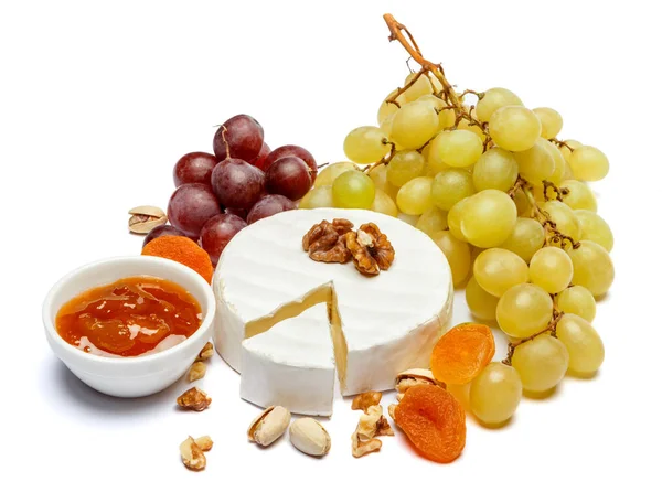 Круглый бри или камамбер сыр и виноград на белом фоне — стоковое фото