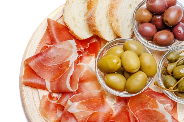 Placa de carne de crudo prosciutto italiano ou jamon espanhol na placa de corte de madeira — Fotografia de Stock