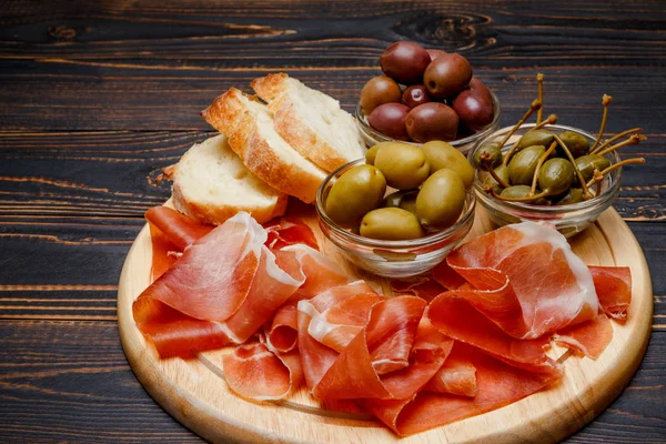 Placa de carne de jamón italiano o jamón español sobre tabla de cortar de madera —  Fotos de Stock