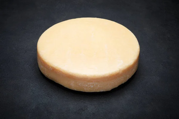 Cabeça redonda inteira de queijo parmesão ou parmigiano duro sobre fundo de concreto — Fotografia de Stock