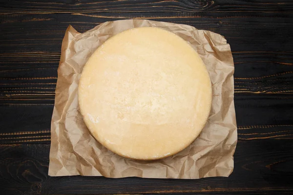 Cabeza entera redonda de queso duro parmesano o parmesano sobre fondo de madera — Foto de Stock