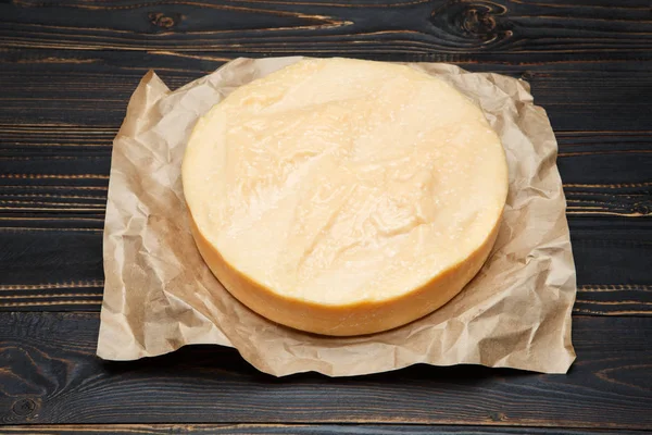 Cabeza entera redonda de queso duro parmesano o parmesano sobre fondo de madera — Foto de Stock