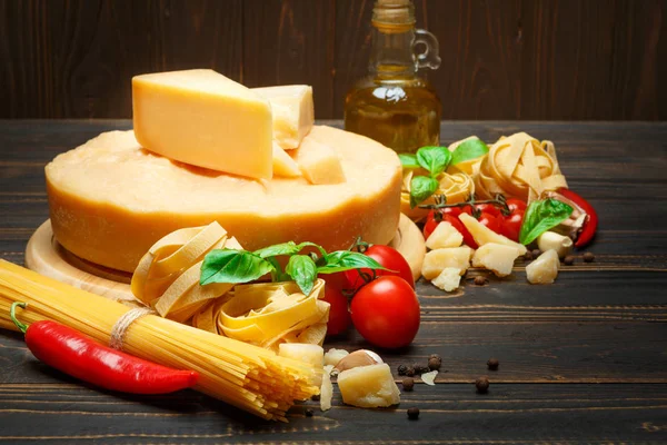 Traditional Italian parmesan or parmigiano cheese, pasta, tomatoes and olive oil — Stock Image Traditional Italian parmesan or parmigiano cheese, pasta, tomatoes and olive oil Royalty Free Stock Photos