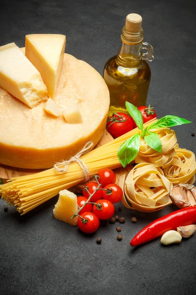 Traditional Italian parmesan or parmigiano cheese, pasta, tomatoes and olive oil Royalty Free Stock Images