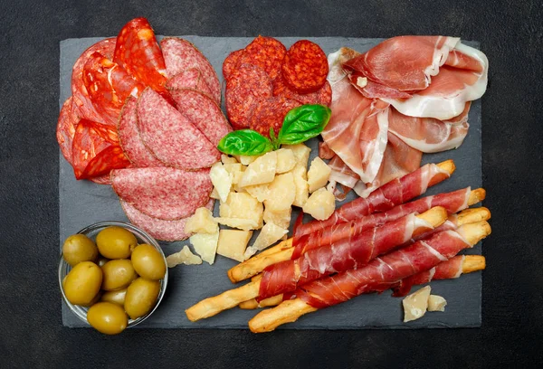 Prato de carne fumada a frio com costeletas de porco, presunto, salame e paus de pão — Fotografia de Stock