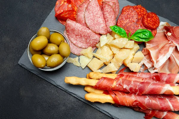 Prato de carne fumada a frio com costeletas de porco, presunto, salame e paus de pão — Fotografia de Stock