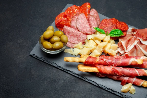 Plato de carne ahumada fría con chuletas de cerdo, jamón, salami y palitos de pan — Foto de Stock