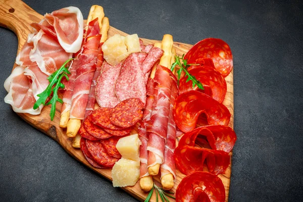 Plato de carne ahumada fría con chuletas de cerdo, jamón, salami y palitos de pan — Foto de Stock