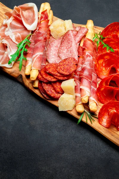 Piatto di carne affumicata fredda con braciole di maiale, prosciutto, salumi e bastoncini di pane — Foto Stock