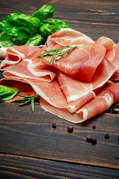 Italian prosciutto crudo or spanish jamon. Raw ham on wooden background — Stock Photo, Image