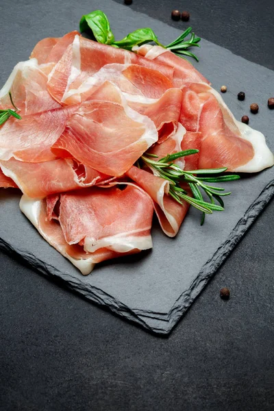 Italiensk prosciutto crudo eller spansk jamon. Rå skinke på hogstplater av stein – stockfoto