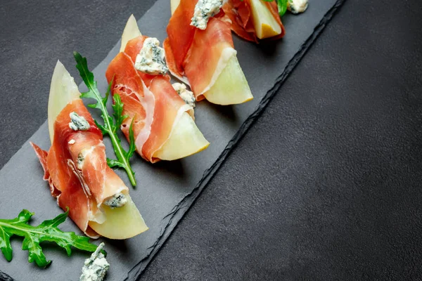 Italiaans eten met meloen en prosciutto op stenen bord — Stockfoto