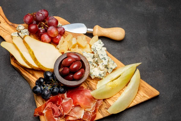 Mięso płyta antipasti przekąska - szynka Prosciutto, ser pleśniowy, melon, winogrona, oliwki — Zdjęcie stockowe