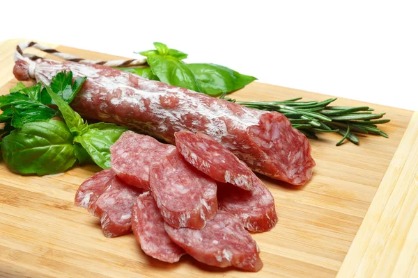 Getrocknete, in Scheiben geschnittene Bio-Salami-Wurst auf Holzschneidebrett — Stockfoto