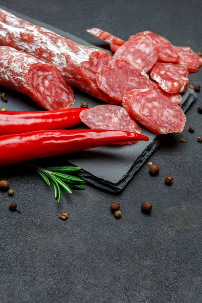 Saucisse de salami bio tranchée séchée sur un plateau de service en pierre — Photo