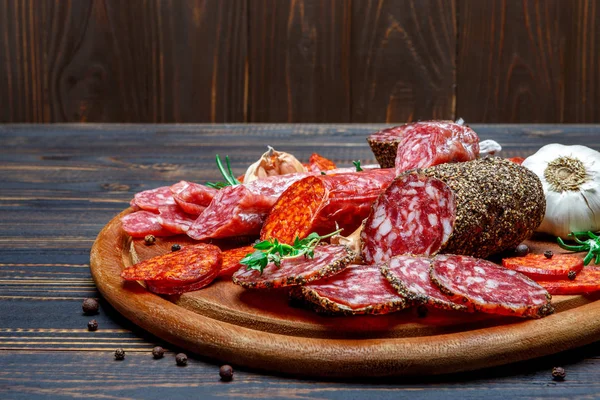 Various types of Dried organic salami sausage on wooden cutting board — Stock Photo, Image