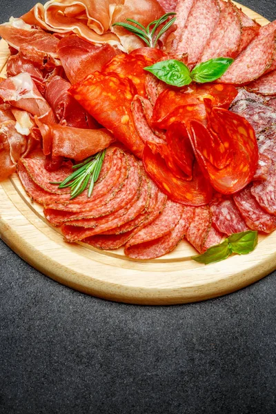 Piatto di carne fredda con salame e salsiccia chorizo su tavola di legno — Foto Stock