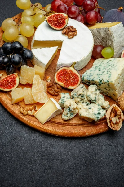 Brie formaggio su una tavola di legno con fichi freschi e uva — Foto Stock