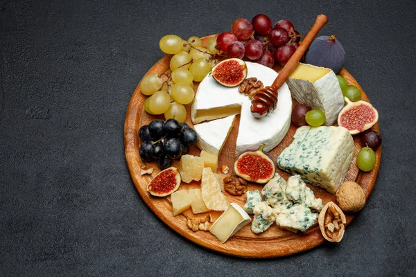 Brie kaas op een houten bord met verse vijgen en druiven — Stockfoto