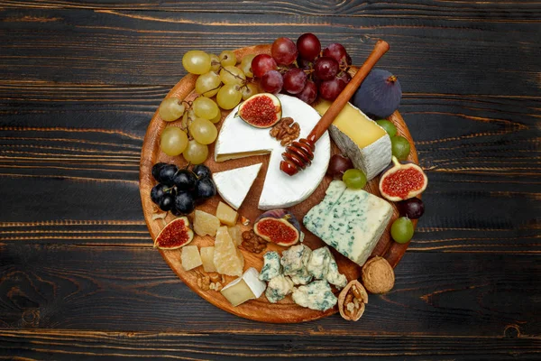 Сыр Бри на деревянной доске со свежим инжиром и виноградом — стоковое фото
