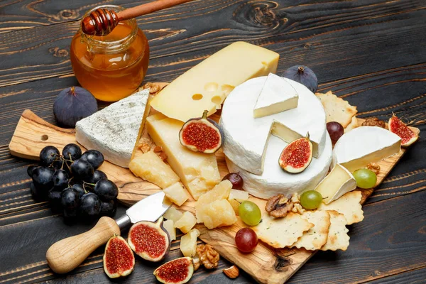 Queso Brie en una mesa de madera con higos frescos y uvas — Foto de Stock