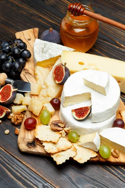Queso Brie en una mesa de madera con higos frescos y uvas — Foto de Stock
