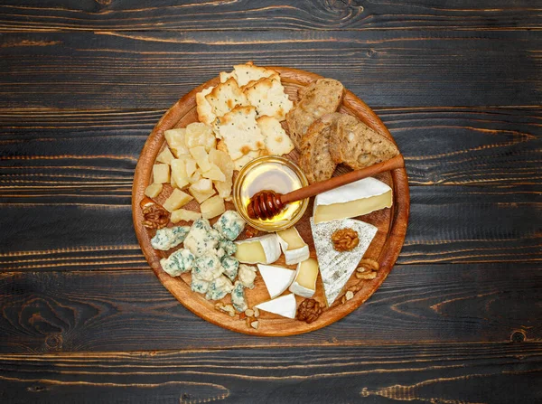 Queijo Brie em uma tábua de madeira com pão e mel doce — Fotografia de Stock