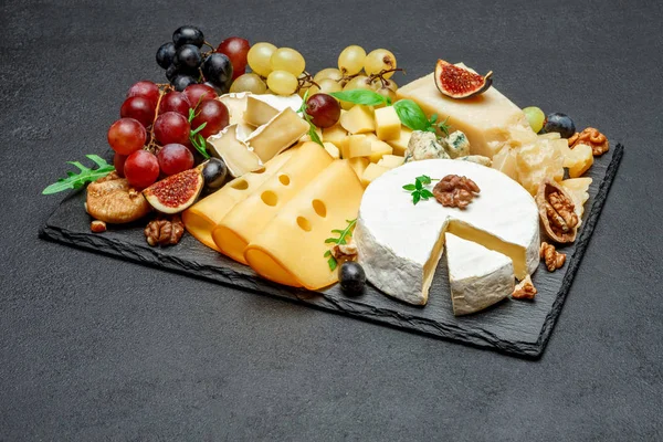 Vários tipos de queijo na placa de serviço de pedra — Fotografia de Stock