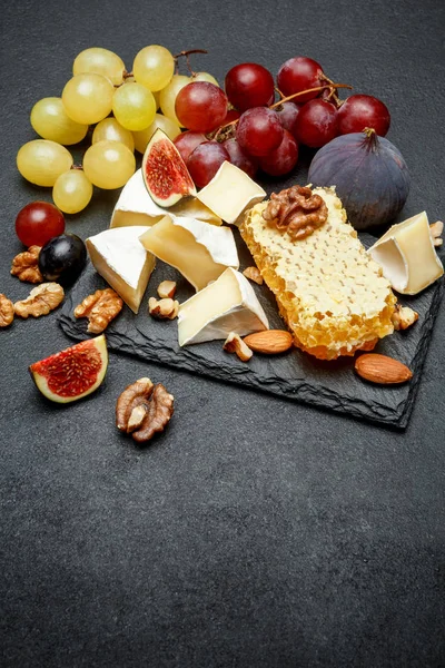 Queijo camembert com mel, figos, nozes sobre placa de pedra — Fotografia de Stock