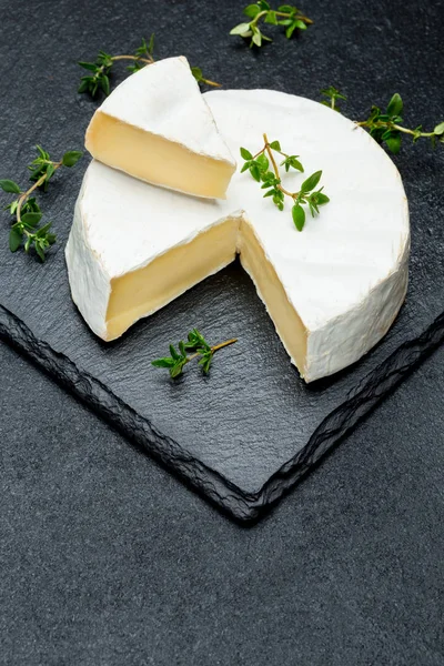 Camembert Käse und schneiden Sie eine Scheibe auf Stein Servierbrett — Stockfoto