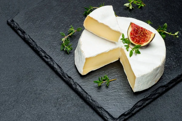 Camembert fromage et couper une tranche sur la plaque de service en pierre — Photo