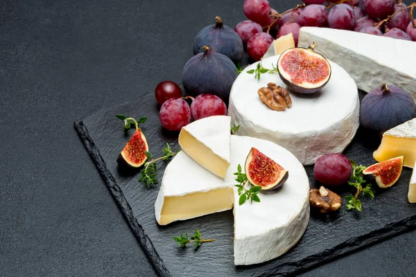 Queijo Camembert e corte uma fatia em tábua de pedra — Fotografia de Stock