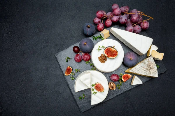 Queso Camembert y cortar una rebanada en tabla de servir de piedra —  Fotos de Stock