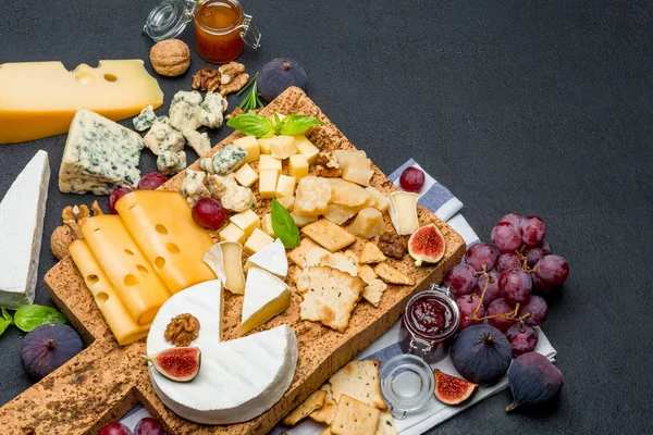 Vari tipi di formaggio brie, camembert, roquefort e cheddar su tavola di legno — Foto Stock