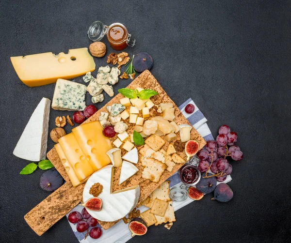 Vari tipi di formaggio brie, camembert, roquefort e cheddar su tavola di legno — Foto Stock