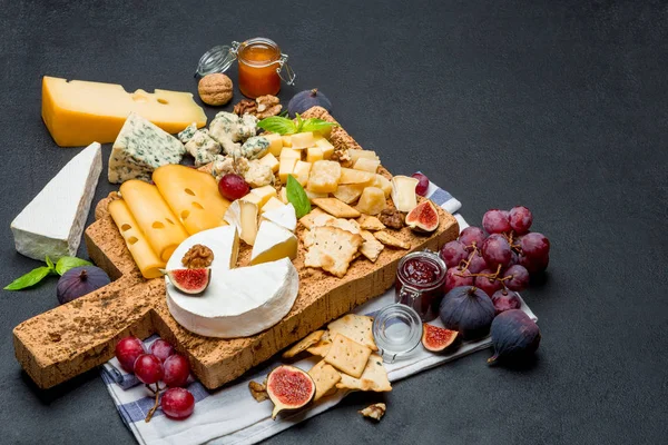 Diverse soorten kaas - brie, camembert, roquefort en cheddar op houten bord — Stockfoto