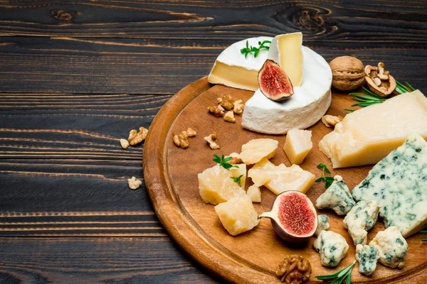 Vari tipi di formaggio brie, camembert, roquefort e cheddar su tavola di legno — Foto Stock