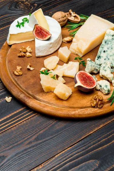 Vari tipi di formaggio brie, camembert, roquefort e cheddar su tavola di legno — Foto Stock